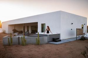 een vrouw in een bad voor een gebouw bij Desert Bloom By The Cohost Company in Joshua Tree
