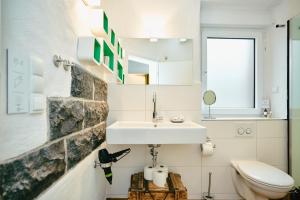 Un baño con lavabo e inodoro en Basalt-Loft, en Kottenheim 33 fotos más