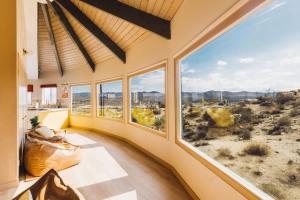 a room with large windows and a view of the desert at Mandarin Escape By The Cohost Company in Yucca Valley