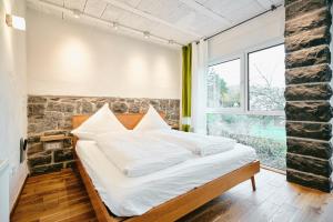 Un dormitorio con una cama y una ventana grande. en Basalt-Loft, en Kottenheim