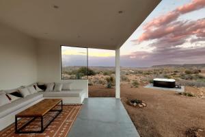 a living room with a couch and a view of the desert at Nexus By The Cohost Company in Pioneertown