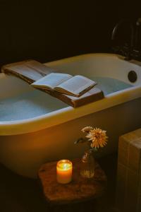 a bathroom with a bath tub with a candle and a book at Wild Moon Ranch Pickleball, Cedar Tub & Views in Julian +61 photos