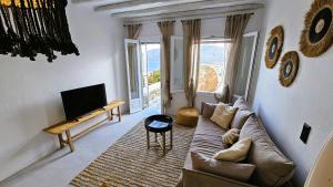 a living room with a couch and a tv at Villa Spika with seaview and shared pool in Kalo Livadi +41 photos