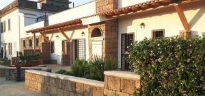 a white building with a stone wall in front of it at Agriturismo Tenuta de Castro in Aprilia