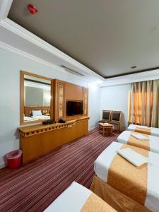 una camera d'albergo con due letti e uno specchio di فندق رهف مكة Rahaf Hotel Maka a Al Khansāk Altre 33 foto