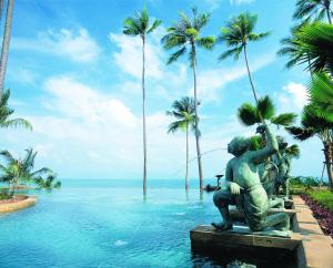 une statue au milieu d'une piscine bordée de palmiers dans l'établissement Anantara Bophut Koh Samui Resort, à Bophut 