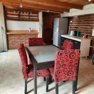 una cucina con tavolo e sedie rosse di dpto MDZ a Comodoro Rivadavia Altre 3 foto