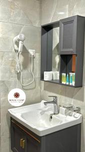 a bathroom with a sink and a phone on the wall at Royal camp in Wadi Rum