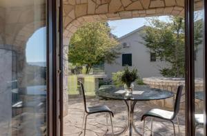 a patio with a table and chairs on a patio at Adrialana in Porozina