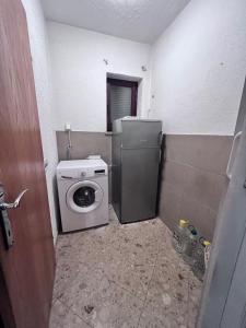 a laundry room with a washer and a refrigerator at Adrialana in Porozina