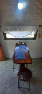 ein Tisch in einem Zimmer mit einem Bett darauf in der Unterkunft CabañaPaz in Santa Rosa de Calamuchita