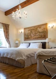 two beds in a bedroom with a chandelier at Achill Guest House in Solihull