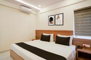 a bedroom with a large bed and a window at Hotel O Mirage Suites in Bengaluru