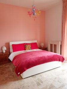 a bedroom with a large bed with a red blanket at Fiori e Frutti Sunshine Home in Almese