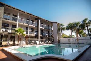 a swimming pool in front of a building with palm trees at Rodeway Inn Near Ybor City - Casino in Tampa