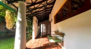 eine Veranda mit einem grünen Stuhl in der Unterkunft Malgedara in Badulla