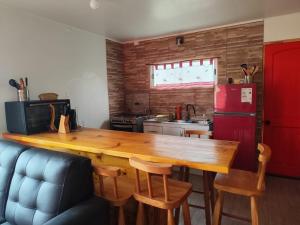a kitchen with a wooden table and a refrigerator at Cabaña Campestre in El Cerrillo