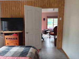 a bedroom with a bed and a flat screen tv at Cabaña Campestre in El Cerrillo