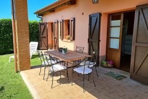 een tafel en stoelen op een patio voor een huis bij Appartamento Papavero Seaside and Pool in La Caduta