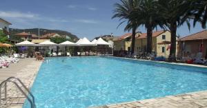 una grande piscina con sedie e ombrelloni di Al Borgo Village a Pietra Ligure