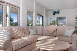 un ampio divano in un soggiorno con finestre di Gone Coastal by Pristine Properties Vacation Rentals a Mexico Beach