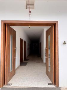 an empty hallway with wooden doors in a building at The Dayal Hotels in Ayodhya