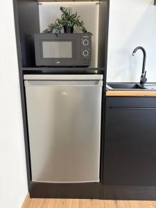 a microwave on top of a refrigerator in a kitchen at Morava apartmán 7 manželská postel a postel pro 3 osobu, parkování zdarma Šafaříkova 855 Uherské Hradiště in Uherské Hradiště