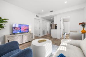 Una sala de estar con un sofá y un televisor. en Cozy By The Blue, en Miami