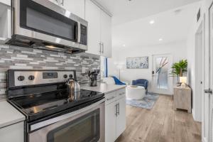 una cocina con estufa y microondas en Cozy By The Blue, en Miami