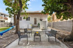 un patio con sillas y una mesa frente a una casa en Cozy By The Blue, en Miami