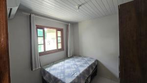 una piccola stanza con un letto e una finestra di Karina Saraiva a Palhoça Altre 13 foto