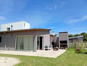 a house with a patio and a yard at Casa en Cobo-Parque Lago in Mar de Cobo