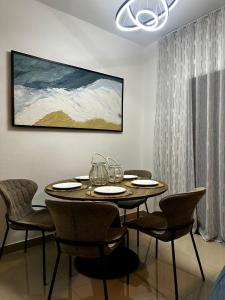 a dining room table with chairs and a painting on the wall at Sol & Arena Bayahibe Apartment in Bayahibe