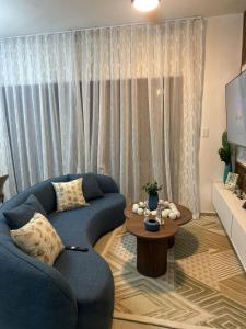 a living room with a blue couch and a table at Sol & Arena Bayahibe Apartment in Bayahibe