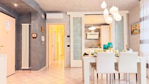 a kitchen and dining room with a table and white chairs at Lady Teresa 2-0 by Ca-Sa Check in Chioggia