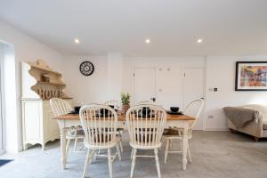 Un comedor con mesa y sillas de madera. en Modern 5-Bed Home EV City Centre 10 min, en Mánchester