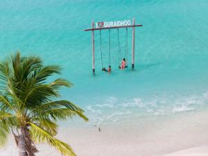 two people on a swing in the water on a beach at h78 Guraidhoo in Guraidhoo +77 photos
