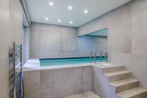 La salle de bains est pourvue d'une baignoire et d'une piscine. dans l'établissement 5 Bed in Chepstow oc-h34098, à Chepstow