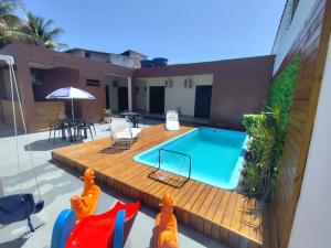 a swimming pool on a deck next to a house at Pousada Espaço Vista Mar in Itanhaém