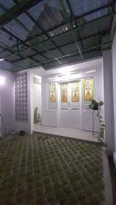 ein Zimmer mit weißen Türen und Buntglasfenstern in der Unterkunft Omah Saha at Kraton in Ngabean