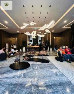 des gens assis dans le hall d'un hôtel dans l'établissement The Lumiere Riverside Apartment View City, à Hô-Chi-Minh-Ville