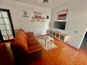 un soggiorno con divano e TV a schermo piatto di Lupita's House a Punta de Mujeres