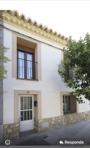 - un bâtiment blanc avec une porte et des fenêtres dans l'établissement La Flor del Azafrán, à Lécera