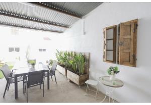 a dining room with a table and chairs and plants at La Flor del Azafrán in Lécera