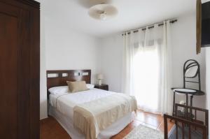 une chambre blanche avec un lit et une fenêtre dans l'établissement La Flor del Azafrán, à Lécera