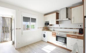 une cuisine avec des armoires blanches et une laveuse et une sécheuse dans l'établissement La Flor del Azafrán, à Lécera 16 autres photos