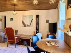 un salon avec une table et des chaises dans l'établissement Le Petit Four à Pain - Maison 4 personnes à la Campagne, à Neuvicq-Montguyon 17 autres photos