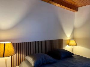 une chambre avec un lit avec deux lampes dessus dans l'établissement Le Petit Four à Pain - Maison 4 personnes à la Campagne, à Neuvicq-Montguyon