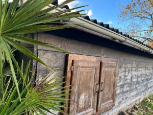 une vieille porte sur le côté d'une maison dans l'établissement Le Petit Four à Pain - Maison 4 personnes à la Campagne, à Neuvicq-Montguyon