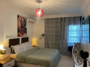 a bedroom with a bed and a window with a fan at Appartement cosy World Rabat in Rabat